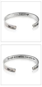 Detail view of engraved inspirational quotes inside silver stainless steel open bracelets