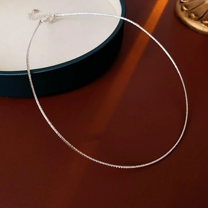 Close-up of silver snake chain necklace with lobster clasp and adjustable extension chain