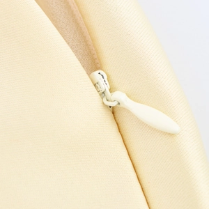 Elegantes beiges Satinkleid-Detail mit hochwertigem Reißverschluss und feiner Köperstruktur
