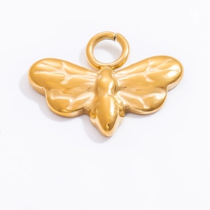 Détail du pendentif papillon doré avec texture métallique martelée et finition brillante