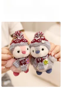 Close-up of cute plush penguin keychains with knit hats and scarves in pink and gray