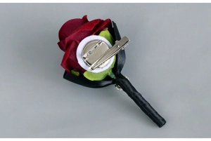 Detail of red rose boutonniere back with metal clip and safety pin attachment