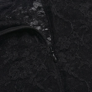 Macro detail of intricate black lace fabric featuring a durable hidden back zipper closure