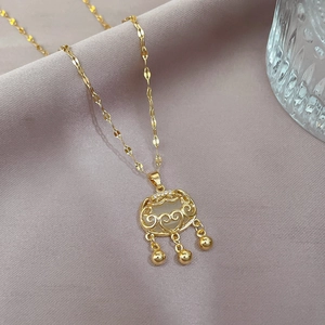 Macro shot of gold-plated long life lock necklace with hollow patterns and jade inlay