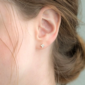 Elegant gold S925 silver stud earrings with four-leaf clover zircon crystals on model