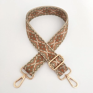 Detail of jacquard geometric bag strap with adjustable light gold metal hardware