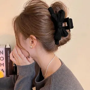 Pince à cheveux élégante en tissu gris foncé avec nœud portée par un mannequin de dos
