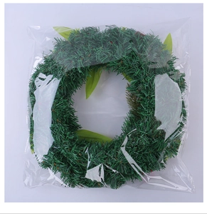 Detailed view of an artificial Christmas wreath with pine needles in clear protective bag