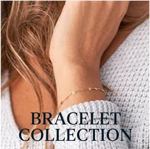 Nahaufnahme eines minimalistischen goldenen Schlangenarmbands über einem Strickärmel