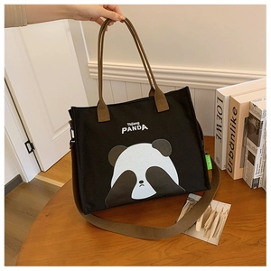 Detail of cute panda print on black canvas tote bag with brown straps and logo tag