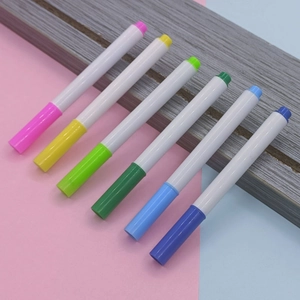 Draufsicht auf ein Set mit 6 bunten Kreidemarkern auf rosa-blauem Hintergrund