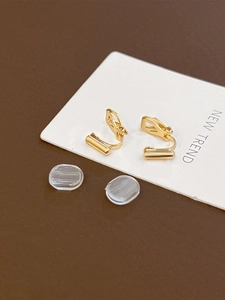 Close-up of golden spiral ear clip converters with soft silicone comfort pads