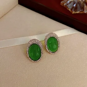 Boucles d'oreilles vintage dorées avec pierre vert émeraude et double bordure en strass