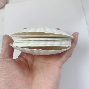 Detail of a white seashell-shaped binder notebook with multi-layer inner pages