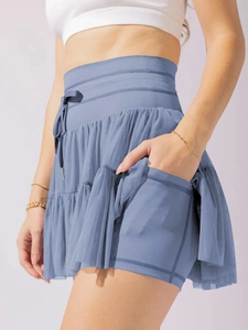 Detail view of the hidden inner pocket on blue pleated mesh high-waisted skort