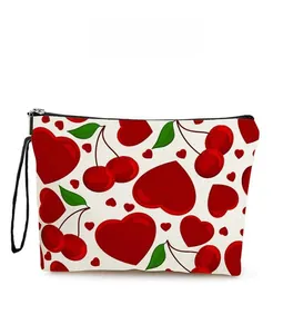Close-up of heart cherry print canvas makeup bag with black zipper and wrist strap