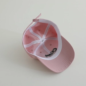 Detail view of pink cotton baseball cap interior with stitching and metal buckle