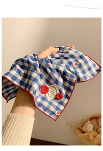 Detail of blue plaid scrunchie with cherry embroidery and hand-made fabric label