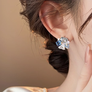 Detailed view of 18k gold plated butterfly crystal earrings worn on a female model