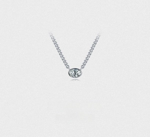Macro shot of silver oval cut cubic zirconia pendant with minimalist curb chain necklace