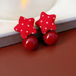 Close-up of red fabric star earrings with white polka dots and smooth pearl beads