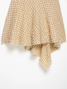 Détail de la robe à carreaux vintage avec plis texturés et bordure en dentelle blanche