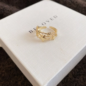 Macro detail of triple-layer star ring with zircons on a gift box
