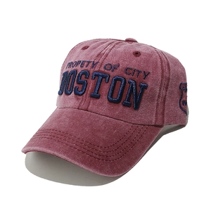 Detail view of the washed red cotton baseball cap with Boston embroidery and vintage texture