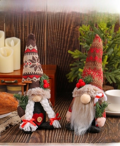 Close-up of knit Christmas gnomes with snowflake hats and candy canes on a wooden background