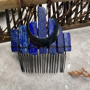 Macro shot of blue crystal stones and black crescent moon on a metal wire hair comb
