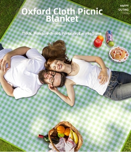 Oxford cloth green checkered picnic mat on grass with outdoor dining basket and wine