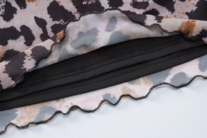 Detailed macro view of lightweight leopard print mesh fabric with ruffled edges and lining