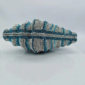 Detailed close-up of shell-shaped luxury evening bag with blue and silver crystals