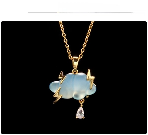 Detail of light blue cloud pendant with gold lightning bolts and teardrop crystal