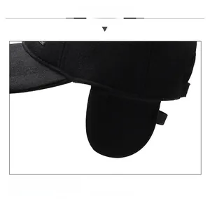 Macro detail of black wool baseball cap featuring fold-down ear flaps for winter warmth