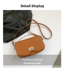 Detail view of brown crossbody bag with asymmetric flap and silver metal ring lock