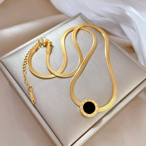 Close-up of gold titanium steel necklace with a Roman numeral pendant on white silk