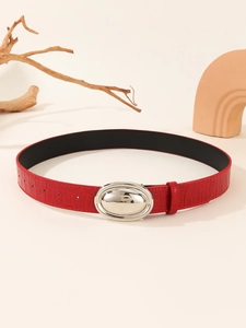 Detail of red crocodile pattern leather belt with a polished silver oval buckle