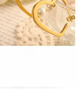 Detailed view of an 18K gold plated heart earrings with white faux pearls on lace