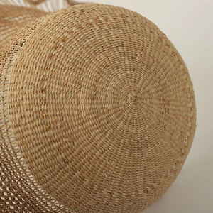 Close-up of hand-woven raffia sun hat showing spiral texture and gold thread details