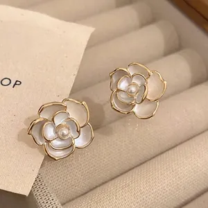 Macro shot of French vintage floral stud earrings with pearls in a beige velvet box
