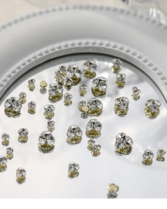 Macro de strass 3D scintillants pour nail art sur une surface miroitante ronde