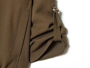 Macro detail of the bomber jacket stitching and silver metal ring buckle attachment