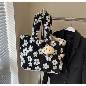 Detailed close-up of plush daisy tote bag texture with cute lamb pendant on a hanger