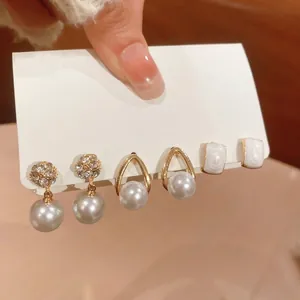 Vintage style pearl earring set featuring gold-tone hoops and sparkling rhinestone studs