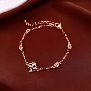 Rose gold plated flower bracelet with oval zircons on luxury leather background