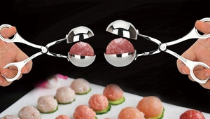 Close-up of stainless steel meatball maker tool showing dual-size molds and handles