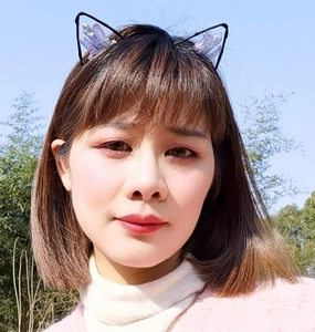 Detailed view of model wearing a black cat ear headband with purple crystal embellishments