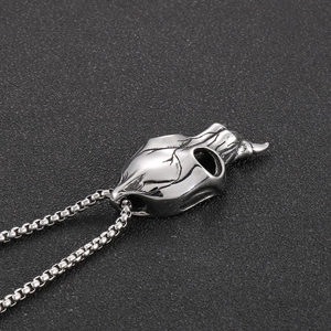 Detailed view of punk style stainless steel bull skull pendant on a silver box chain