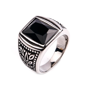 Macro shot of silver stainless steel ring with square black gemstone and carved details